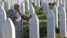 A woman cries next to the grave of her relative at the Potocari memorial cemetery near Srebrenica. (file photo)