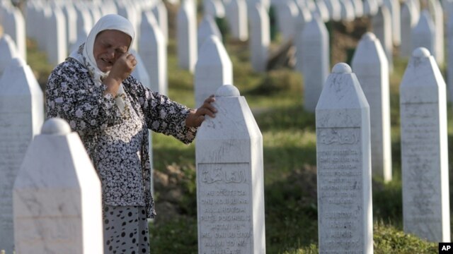A woman cries next to the grave of her relative at the Potocari memorial cemetery near Srebrenica. (file photo)