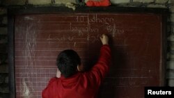 Тбилиси маңындағы Макарта елді мекеніндегі мектеп шәкірті сабақта тақтаға жазып тұр. 10 сәуір 2013 жыл. (Көрнекі сурет.)