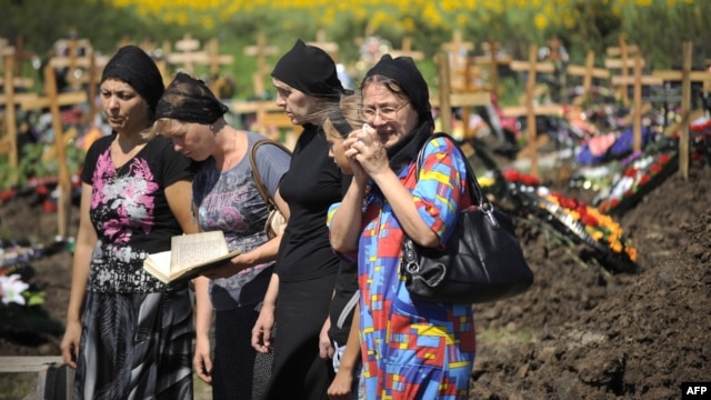 Friends and relatives of a flood victim mourn in a cemetery in Krymsk in the southern Krasnodar territory on July 9.