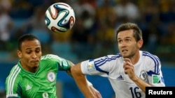 Nigeria's Peter Odemwingie (left) challenges for the ball with Bosnia's Senad Lulic during their 2014 World Cup Group F soccer match at the Pantanal arena in Cuiaba.