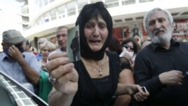 A woman holds a picture of her son, whom she says became an invalid from injuries sustained while in prison, during a protest rally in Tbilisi on September 19.