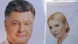Украина президент сайлауы науқаны кезінде кандидаттар Юлия Тимошенко (оң жақта) мен Петр Порошенконың қатар ілініп тұрған плакаттары. Украина, Львов, 21 мамыр 2014 жыл.