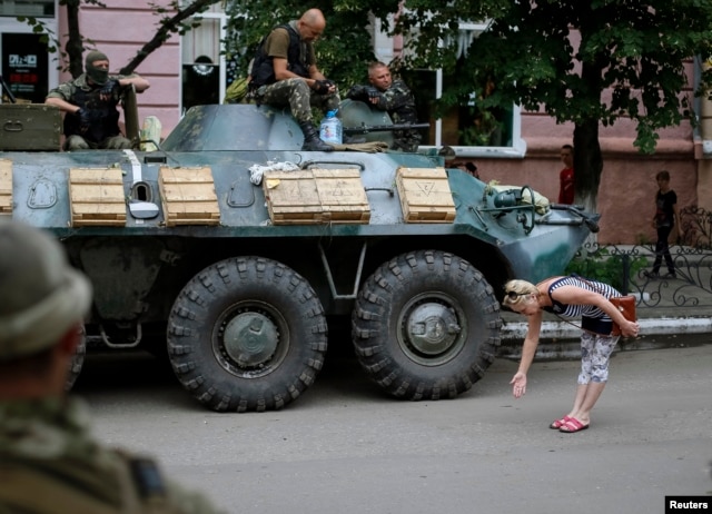 Жительница Славянска приветствует украинских солдат, 15 июля 2014