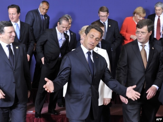 French President Nicolas Sarkozy gestures as he and other EU leaders leave a family photo at the start of the European Council summit in Brussels on June 17 2010 (Photo: AFP)
