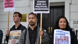 Жайна Айдархан (справа), супруга Арона Атабека, и Аскар Айдархан (в центре), их сын, проводят акцию протеста напротив посольства Казахстана в Лондоне. 5 октября 2012 года.