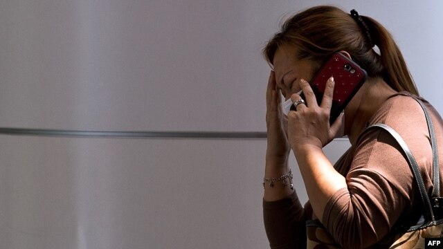 A woman talks on the telephone at a reception center at the Kuala Lumpur International Airport for the families and friends of passengers after an airliner went missing on March 8.