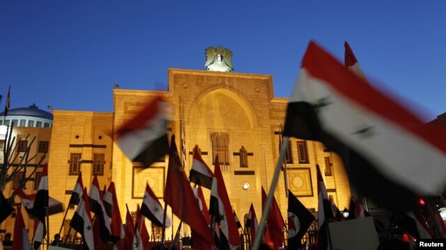 Syrian activists wave flags during a sit-in protest outside the parliament building in Damascus on February 21.