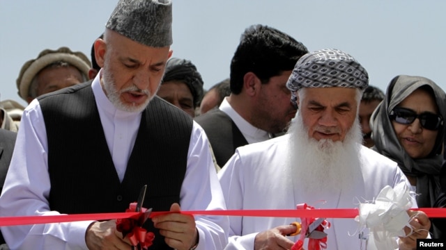 President Hamid Karzai (left) inaugurates a power plant north of Kabul in June with Mohammad Ismail Khan, who says he has Karzai's full support.