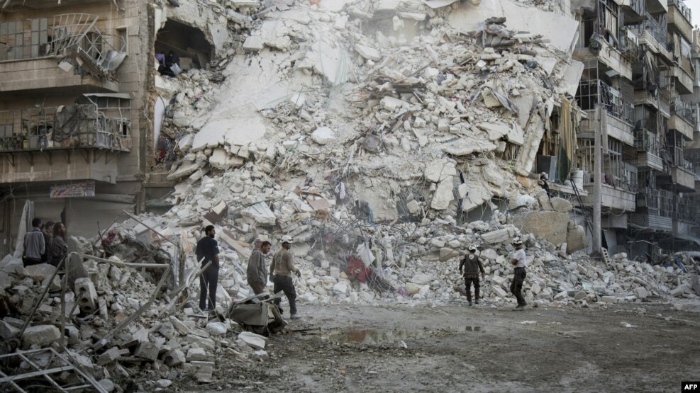 Members of the Syrian Civil Defense, known as the White Helmets, search for victims amid the rubble of a destroyed building following reported air strikes in the rebel-held Qatarji neighborhood of the northern city of Aleppo on October 17.