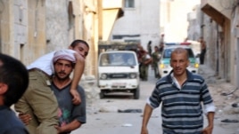 Syria - Syrian rebels assist a comrade during clashes with government troops in the Salhin district of the northern city of Aleppo, 31Jul2012