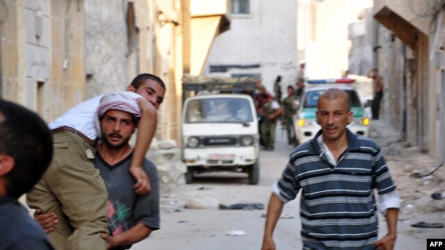 Syria - Syrian rebels assist a comrade during clashes with government troops in the Salhin district of the northern city of Aleppo, 31Jul2012