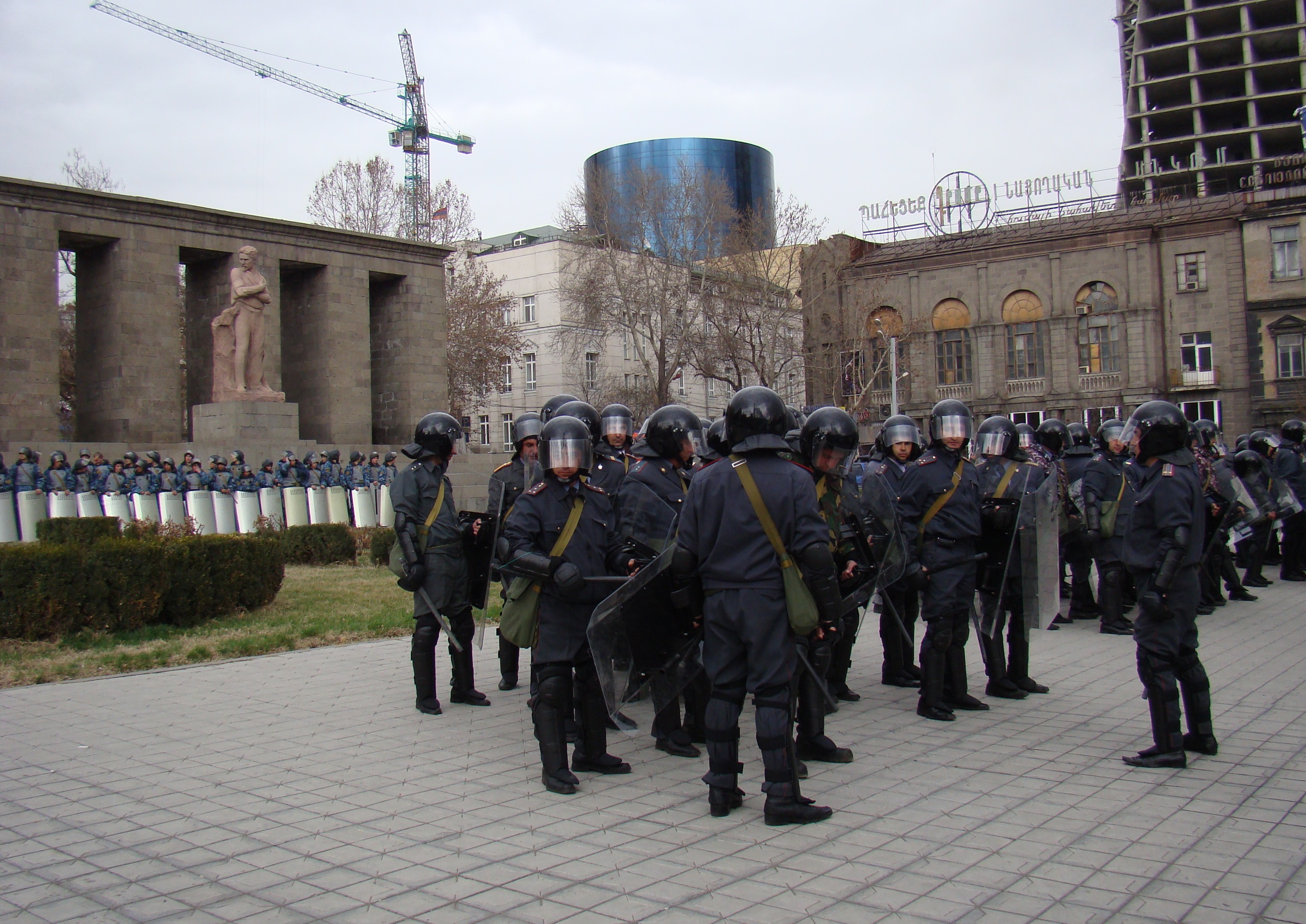 Security forces on March 21 guard a downtown site where demonstrators and police clashed three weeks earlier