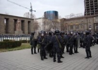 Security forces on March 21 guard a downtown site where demonstrators and police clashed three weeks earlier