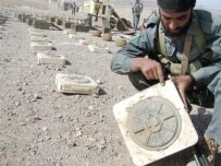 An Afghan policeman points to a mark on a land mine found in Ghurian district in Herat (AFP)