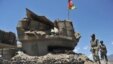 Afghan border policemen walk past a bunker, destroyed during recent clashes between Afghan border police and Pakistani troops in Goshta district of Nangarhar Province.