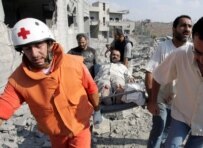 Rescue workers helping a victim of today's Israeli air strike in Qana (epa)