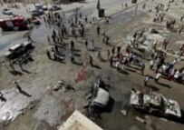 Iraqis gather at the scene of this week's bloody bombing in Baghdad