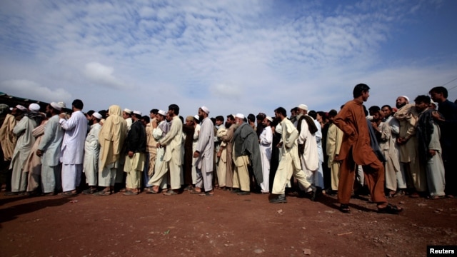 Internally displaced Pakistani men line-up to be registered at the UNHCR-supported Jalozai camp.
