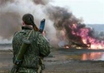 A Russian soldier watches an oil well burn (file photo) (AFP)