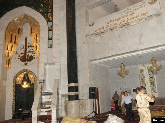 Security personnel inspect the site of a bomb attack inside the Umm al-Qura mosque in Baghdad.