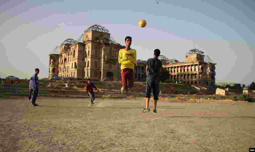 Afghan boys play with a soccer ball, beside the war-ravaged Dar-ul-Aman palace, on the outskirts of Kabul. (epa/Hedayatullah Amid)
