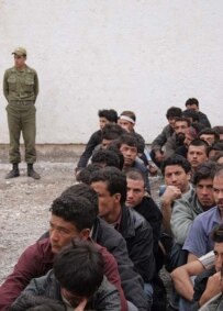 Iranian guard watches over Afghan refugees awaiting deportation in May (Fars)