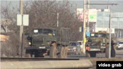 Russian troops and tanks head off to take part in military drills in Simferopol.
