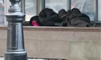 Homeless men crouching over a Moscow ventilation shaft on 18 January (epa)