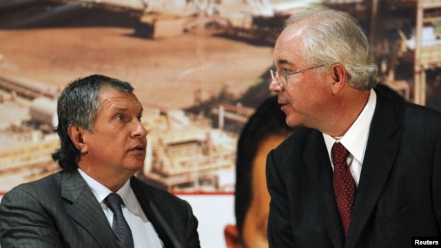 Venezuelan Energy Minister Rafael Ramirez (right) speaks with Rosneft President Igor Sechin in Caracas on January 29.
