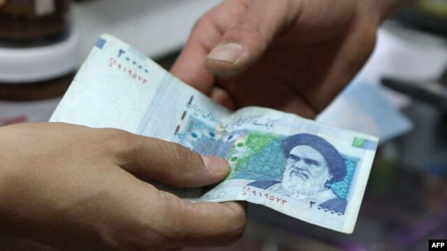 A woman pays with a 20,000-rial banknote in a grocery store in Tehran.