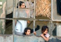 Children in Baghdad watch as police secure the area following a car bombing in July 2006 (epa)