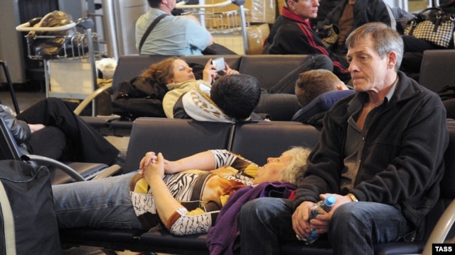 Passengers rest while waiting for a renewal of air traffic from Sheremerevo airport in Moscow on April 16.