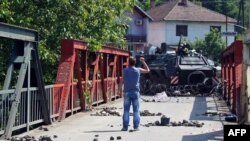 An ethnic Serb gestures at NATO troops following clashes in northern Kosovo.