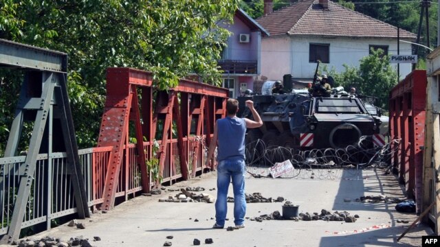 An ethnic Serb gestures at NATO troops following clashes in northern Kosovo. 