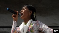 Myanmar opposition leader Aung San Suu Kyi speaks to migrant workers from her country at a community center on the outskirts of Bangkok.