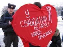 A policeman detains a man dressed as a Valentine's heart (RFE/RL)