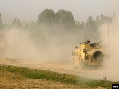 U.S. soldiers patrol the site of a roadside bomb blast in Konduz.