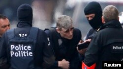 Belgian police take part in a search in the Brussels borough of Schaerbeek following deadly bombings in Brussels on March 22 that were claimed by Islamic State and killed at least 35 people.