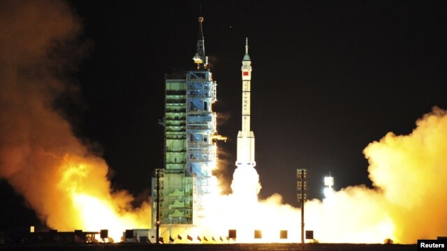A modified model of the Long March CZ-2F rocket carrying an unmanned spacecraft blasts off from the launch pad at the Jiuquan Satellite Launch Center in northwest Gansu Province.