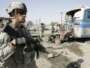 A U.S. soldier stands at the site of a bomb attack in Kirkuk on August 25. Continuing violence means the remaining 50,000 troops will still have much to do.