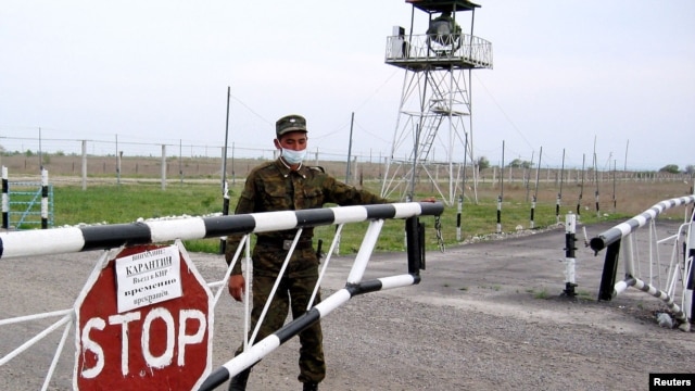 A border guard closes a barrier at the Korgas crossing, the largest on the 1,500-kilometer Kazakh-Chinese border.