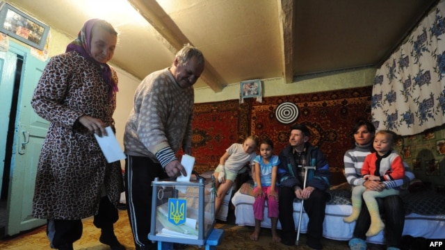 An elderly couple casts their ballots in the village of Rusaki in Ukraine's national elections for a new parliament on October 28.