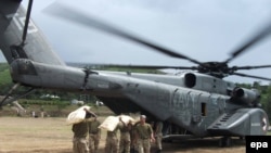 Pakistani soldiers load food supplies for stranded flood victims onto a U.S. Navy helicopter for distribution in August 2010.