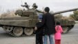 Local people watch as a pro-Russian rebel tank column passes by in the Luhansk region on October 20. Both Kyiv and the rebels say they have begun withdrawing tanks and smaller weapons from the front line in eastern Ukraine. 