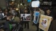 Iranian students hold up pictures of Iranian scientist Mostafa Ahmadi-Roshan, who was killed in a bomb blast on January 11,  as they wait for the arrival of the IAEA delegates at Tehran