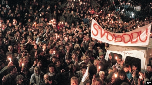 Thousands of people gather under a banner reading "Liberty" flashing Victory signs in an anti-Communist rally 27 November 1989 in Prague.