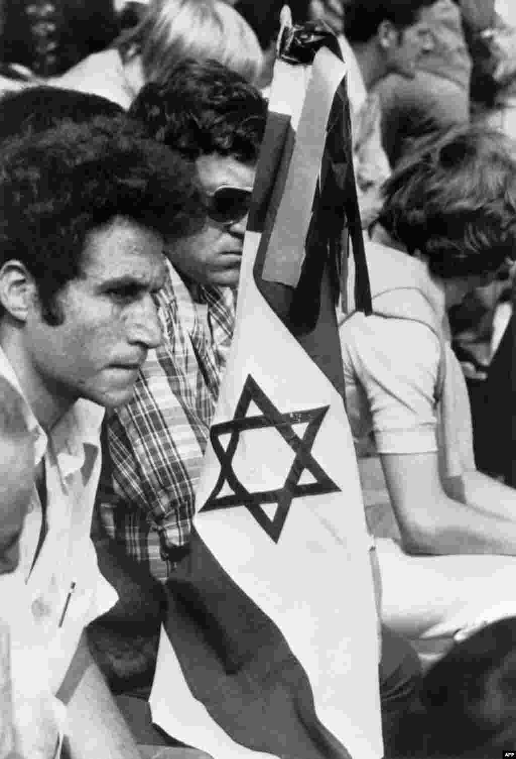 Members of the Israeli team holding an Israeli flag mourn during a memorial ceremony held at Olympic Stadium on September 6, 1972.
