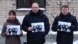In a Facebook photo, three people, including Uladzimer Labkovich (right), hold up photos of the 