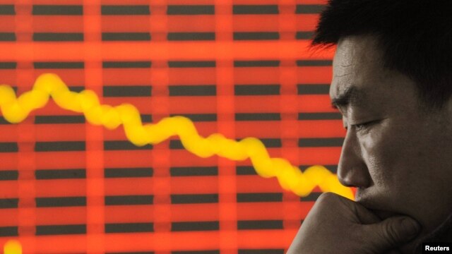 An investor reacts in front of an electronic board showing stock information at a brokerage house in Taiyuan, Shanxi Province. (file photo)